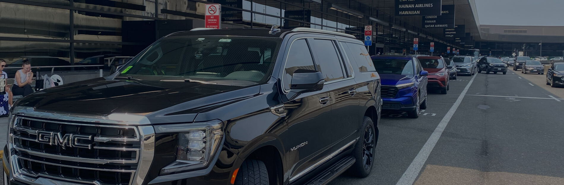 Professional chauffeur assisting passenger into black luxury SUV at SeaTac — Seattle Airport car service by Starline Town Car.