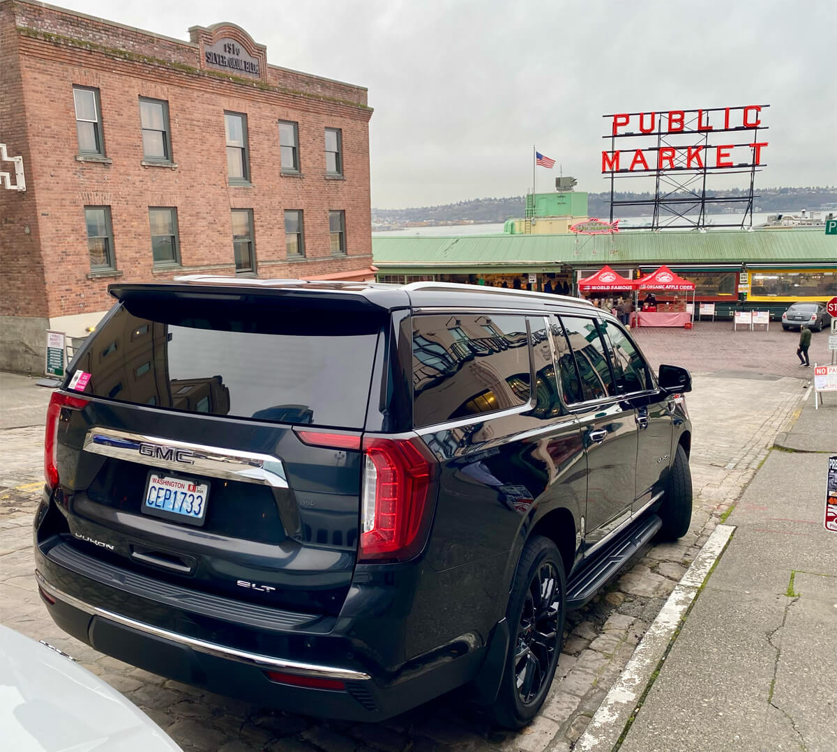 Starline's limousine dropping passengers in front of the Public Market Center Clock & Sign in downtown Seattle