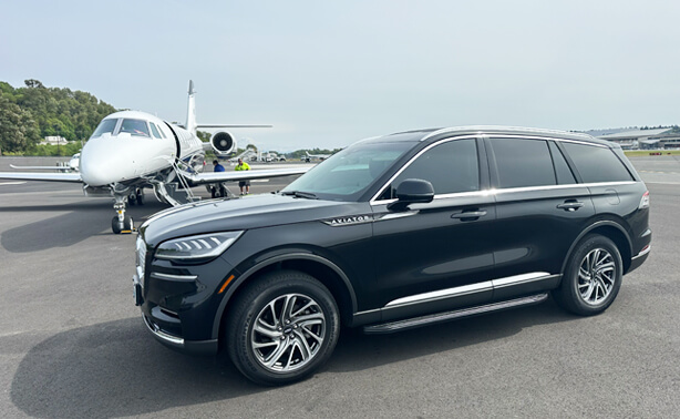 Luxury black SUV providing private chauffeur service at a Seattle airport runway