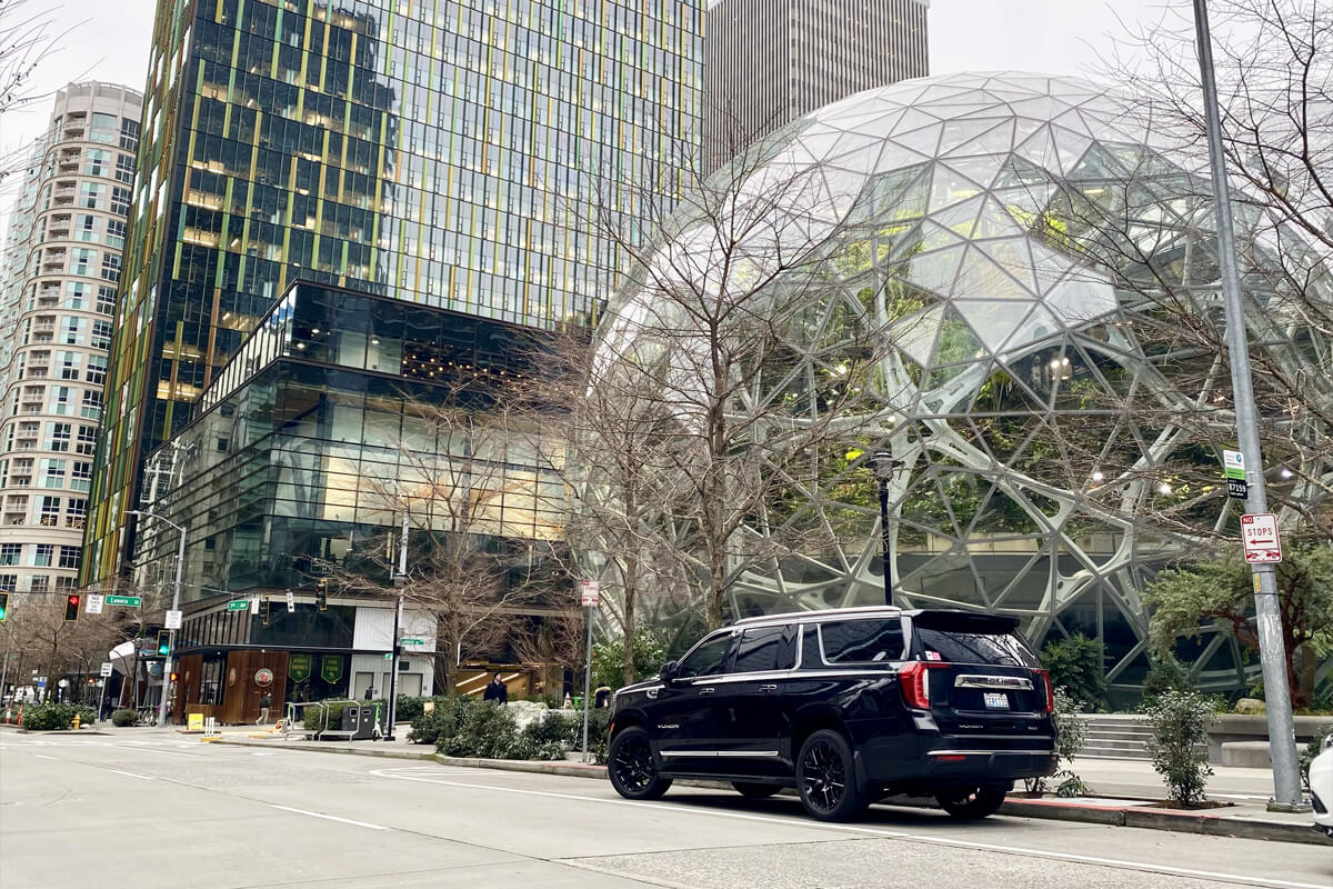 Starline's black luxury SUV parked outside the Amazon Spheres in downtown Seattle, representing premium corporate transportation services.
