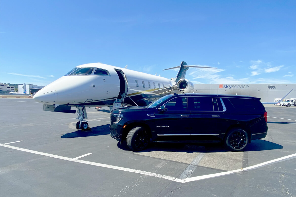 Starline's luxury black SUV positioned beside a private jet on the tarmac, illustrating premium executive airport transportation service.