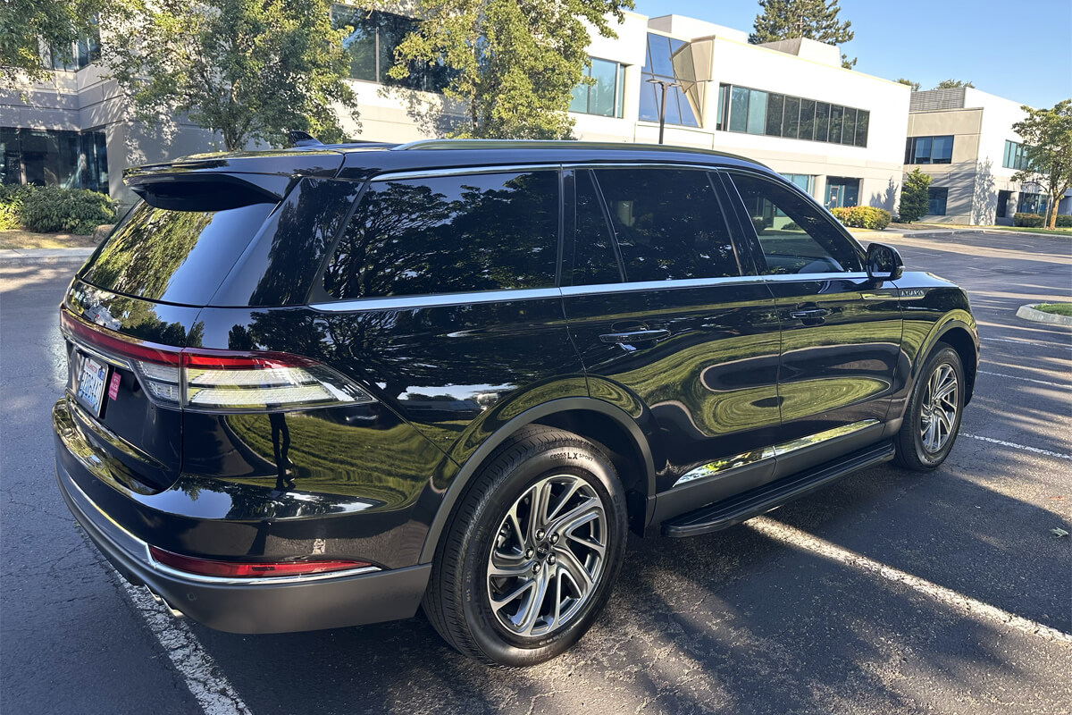 Starline's black luxury SUV parked outside a modern office building, showcasing professional corporate transportation services.