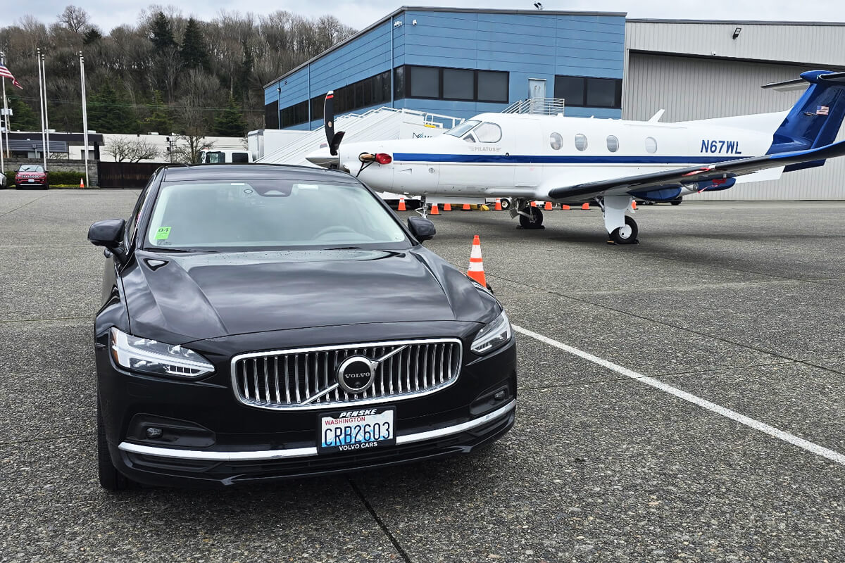 Starline's black Volvo sedan beside a private aircraft at Modern Aviation Seattle, ready for a private aviation pickup.