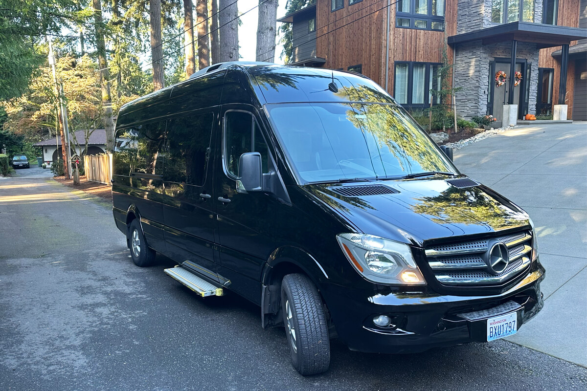 Black Mercedes Sprinter van providing private car service in a residential Kirkland neighborhood