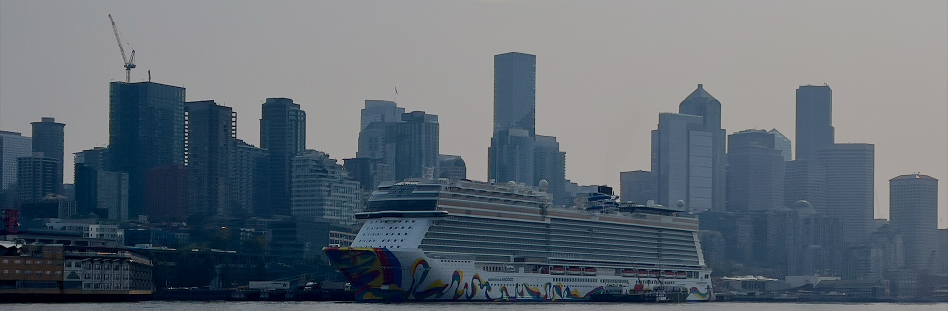 Cruise ship docked in Seattle with the downtown skyline in the background.