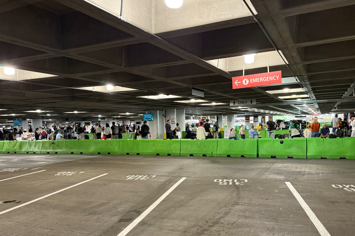 Crowds waiting at the Uber and Lyft ride share pickup area on the 3rd floor of the Sea-Tac airport parking garage.