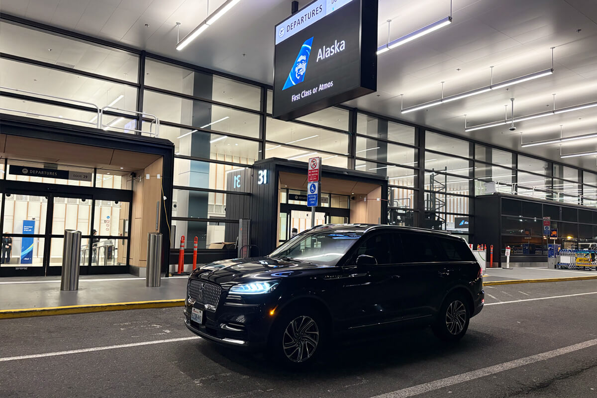 Black SUV at Sea-Tac Airport departures curb outside the Alaska Airlines terminal