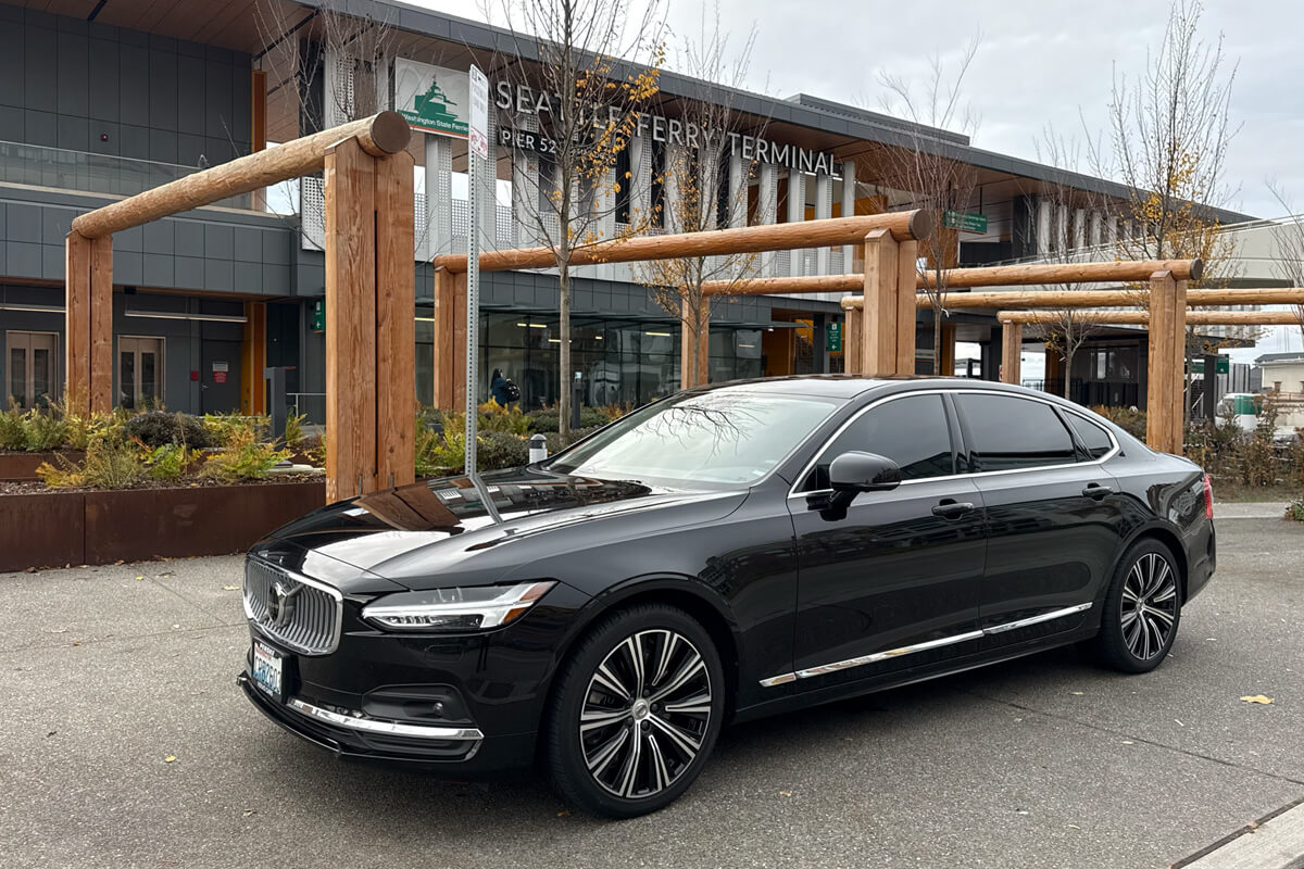 Black Volvo sedan parked outside the Seattle Ferry Terminal for private chauffeur transportation.