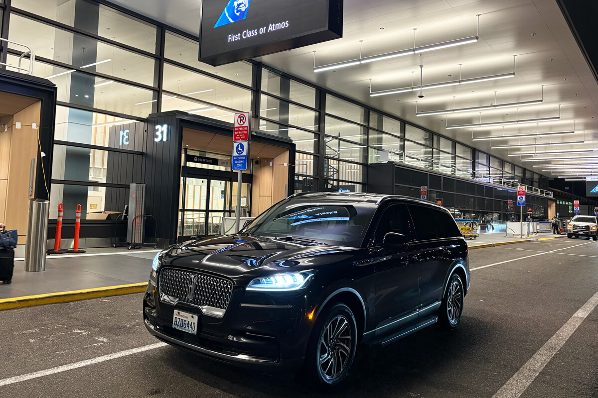 Black Lincoln SUV at airport curbside pickup area for private Sammamish airport transportation