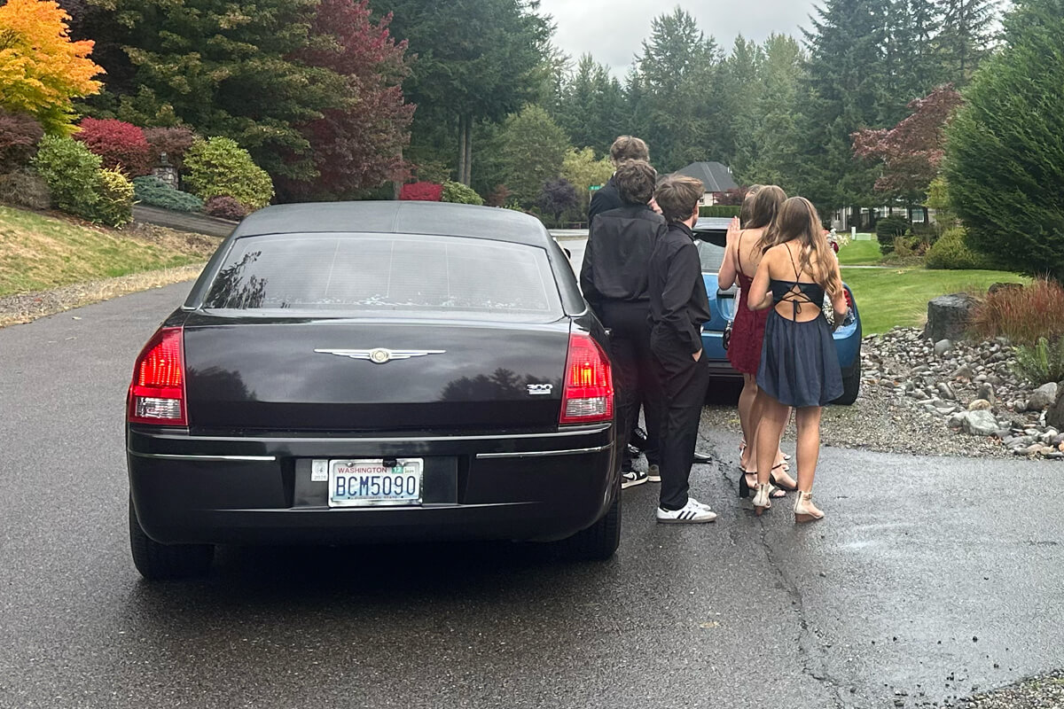 Black limousine arriving for prom pickup in the Seattle area, with students boarding for a special event ride.