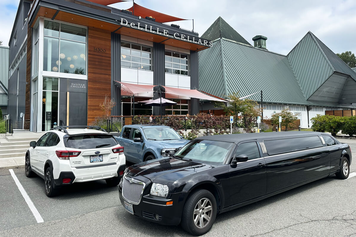 Black stretch limousine parked outside DeLille Cellars for private Woodinville winery transportation.