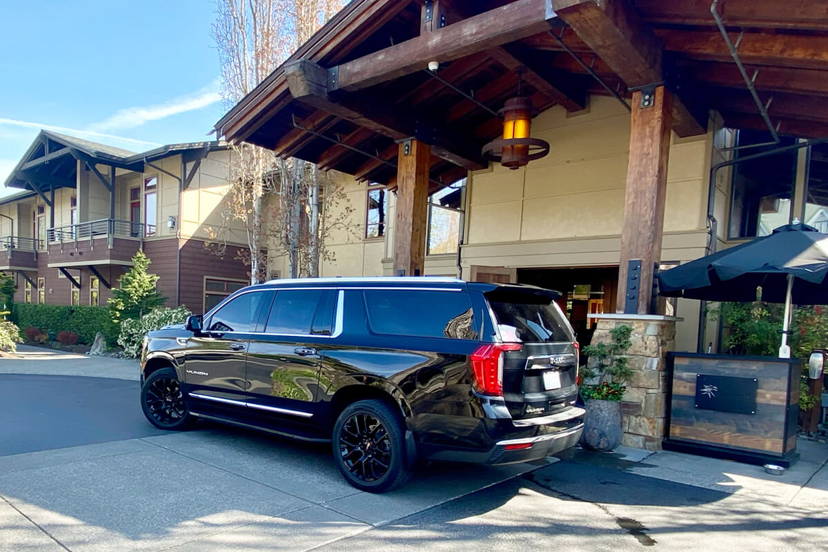 Black Chevrolet Suburban parked in front of Willows Lodge for private Woodinville transportation service.