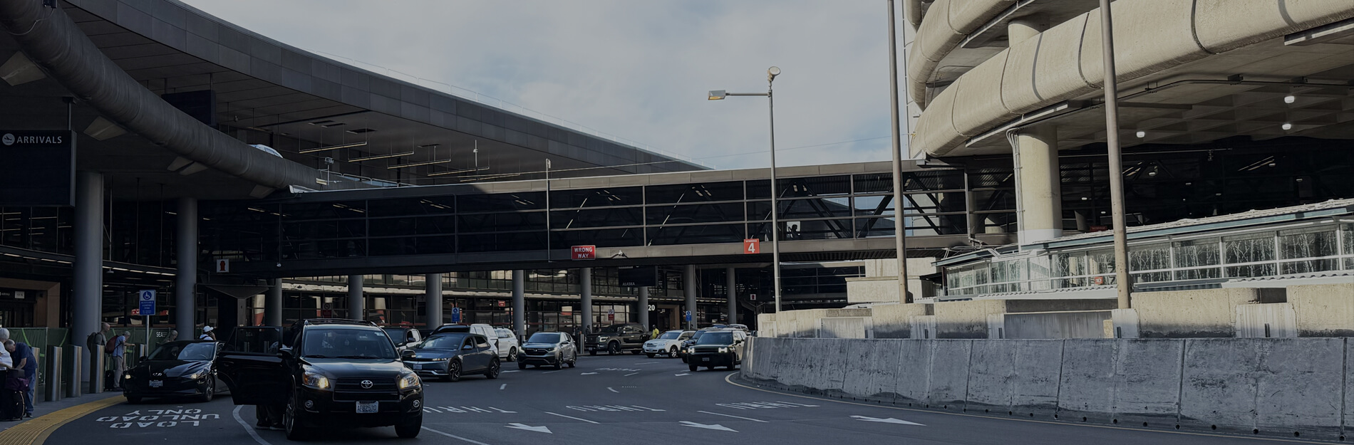 SeaTac arrivals roadway with terminal parking structure on the right side