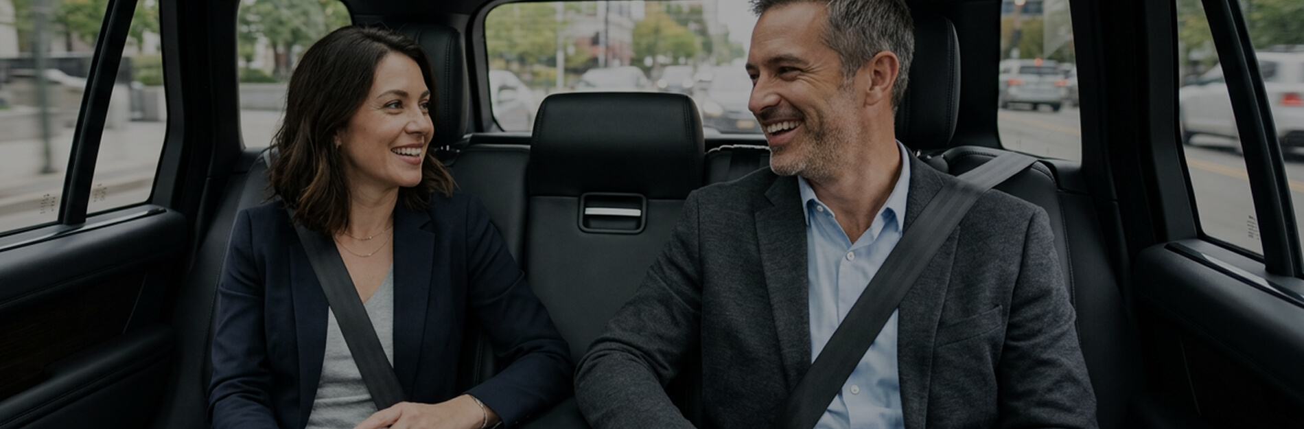 Two travelers riding comfortably in the back seat of a private SUV