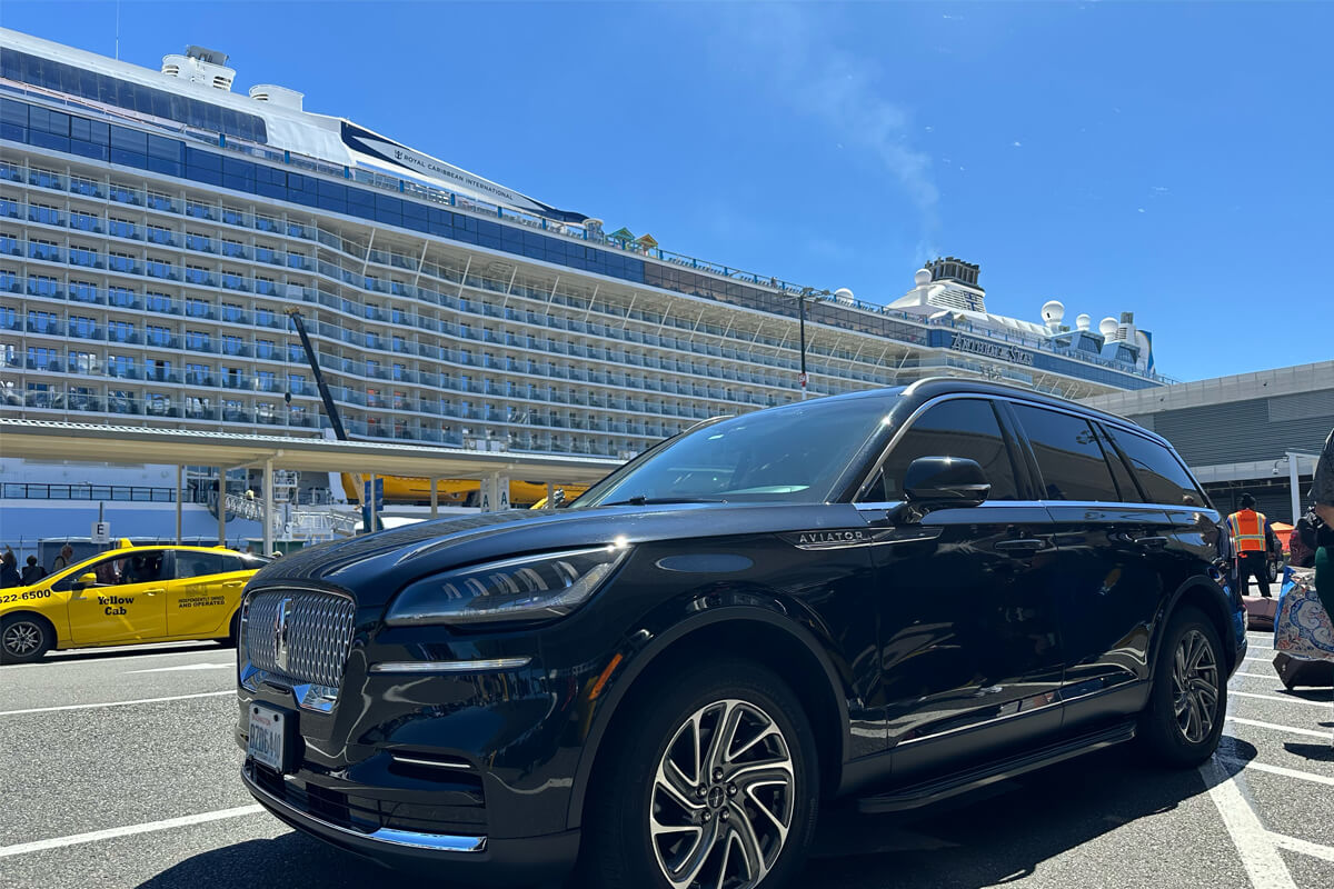 Black Lincoln Aviator SUV at Seattle cruise terminal beside a Royal Caribbean ship for private cruise transfer service