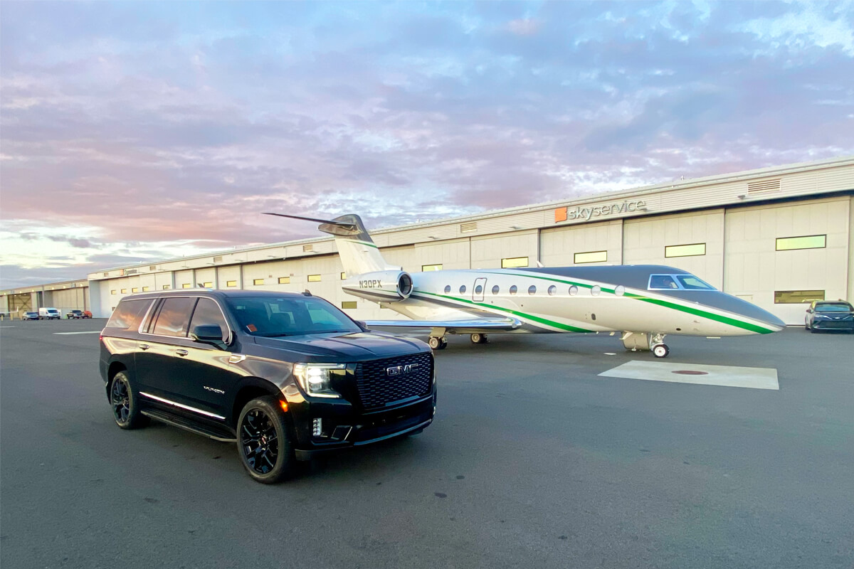 Black GMC SUV parked in front of a private jet outside Skyservice for Seattle FBO pickup and drop-off service