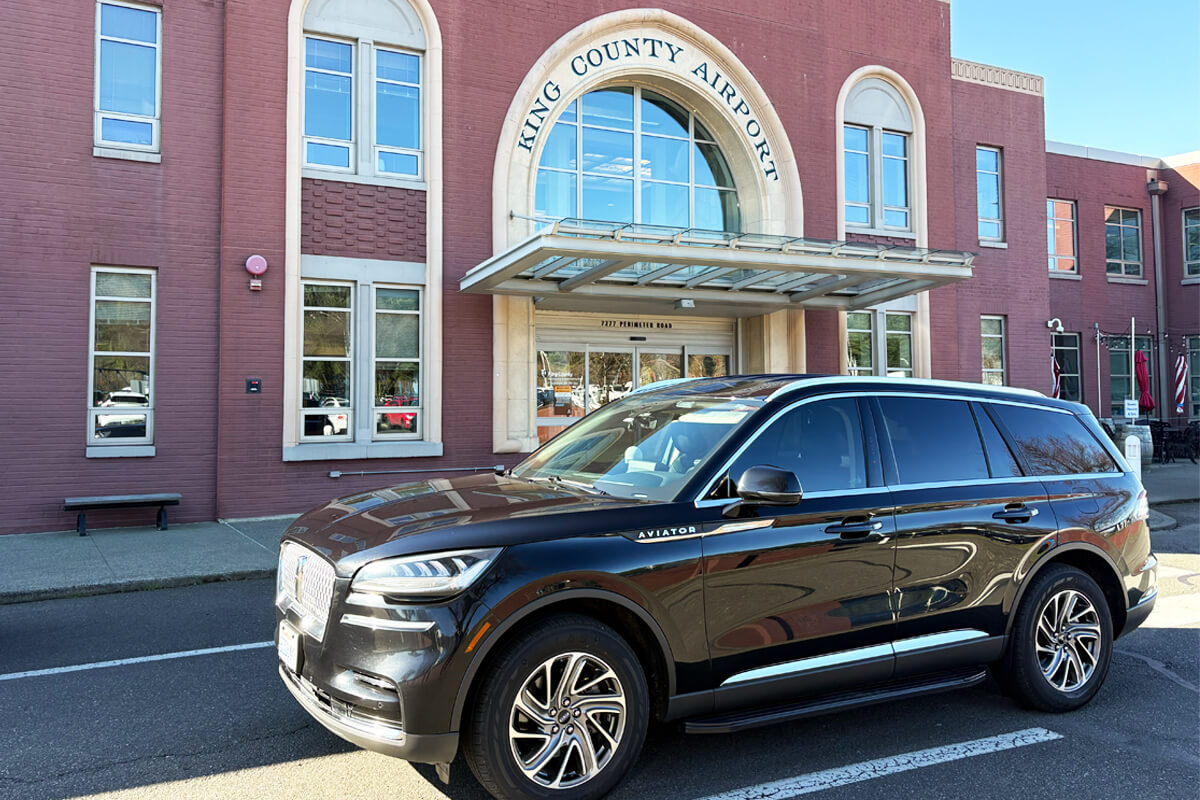 Black Lincoln Aviator parked outside King County Airport terminal for Seattle private aviation ground transportation