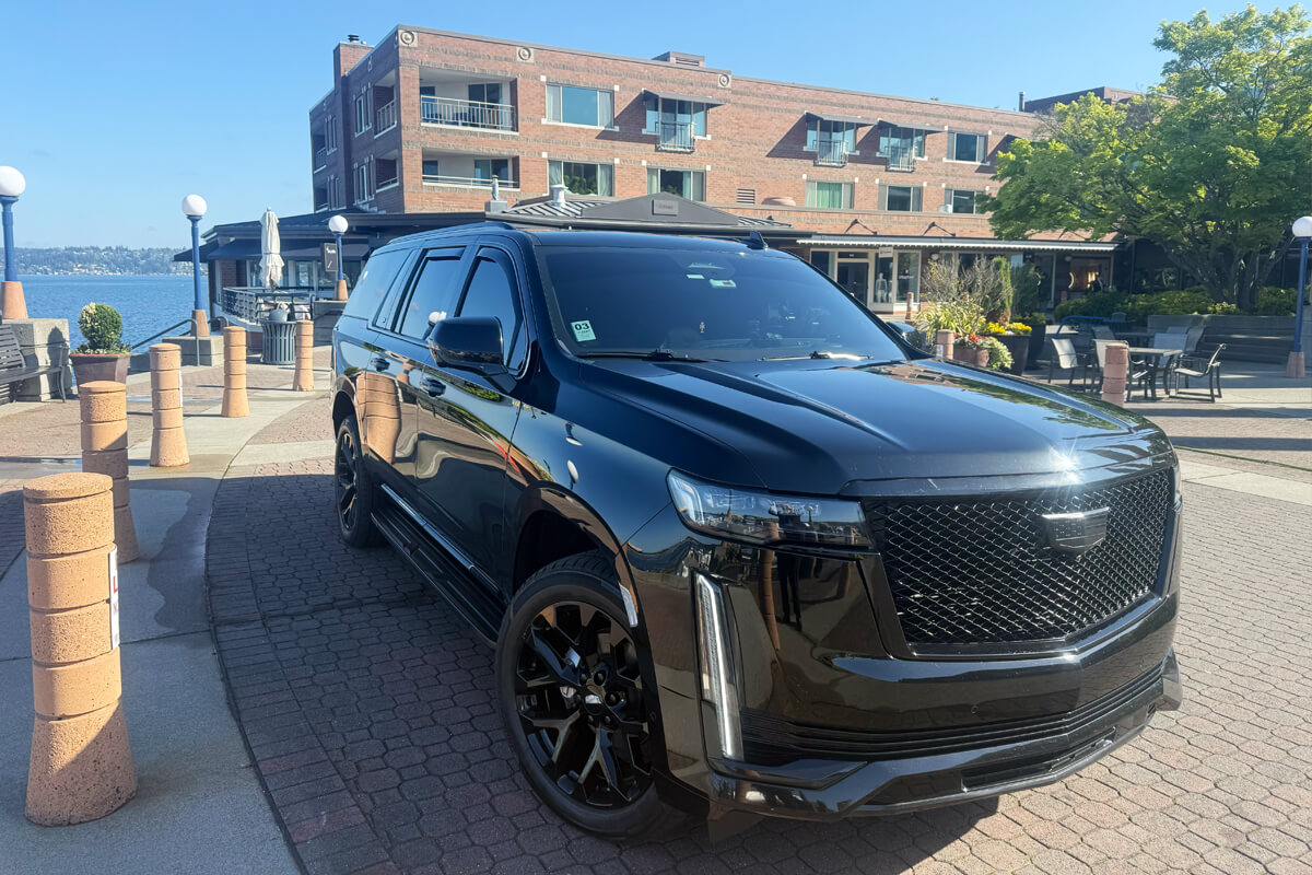Black Cadillac SUV parked at a waterfront hotel entrance
