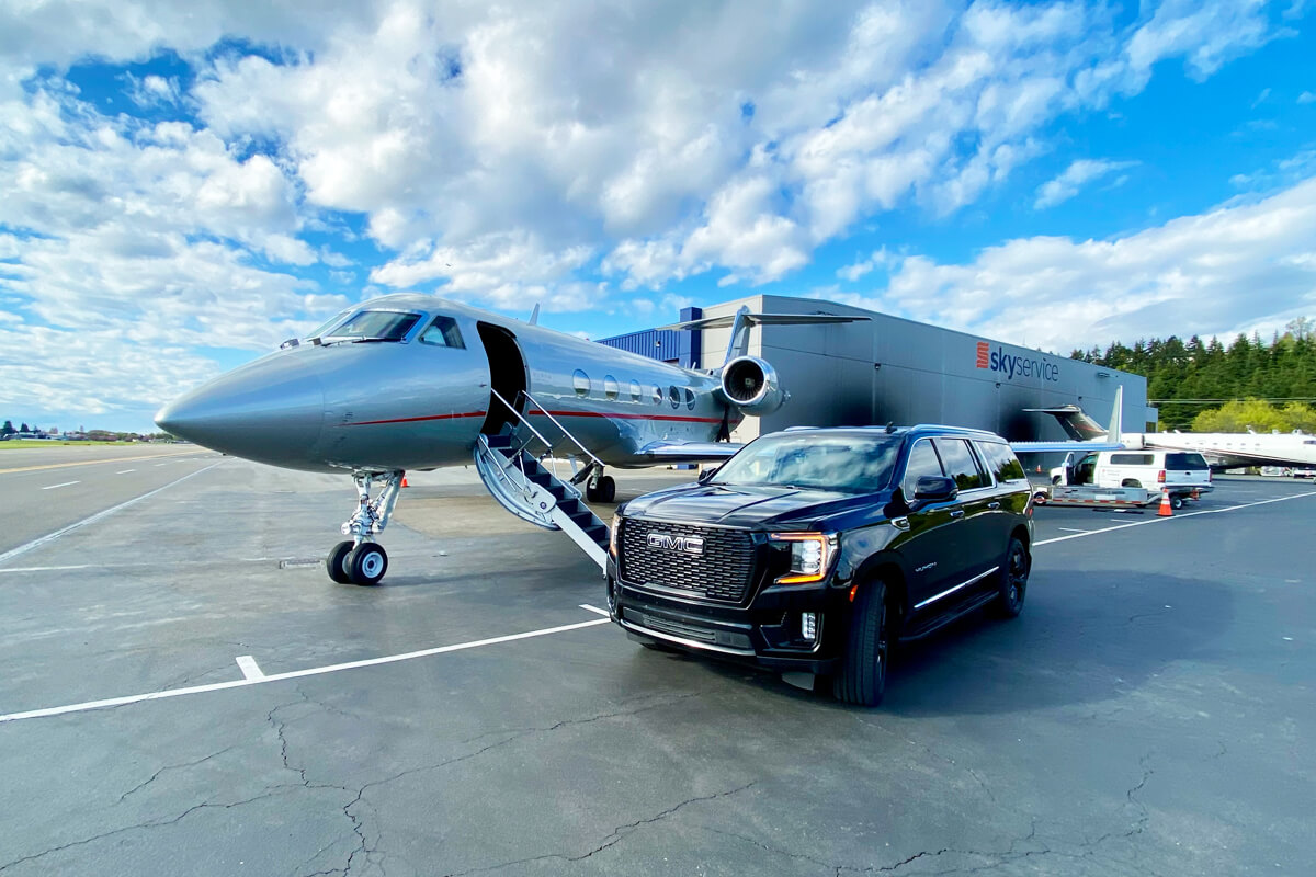 Black SUV beside a private jet at Skyservice for Seattle private aviation and executive transportation