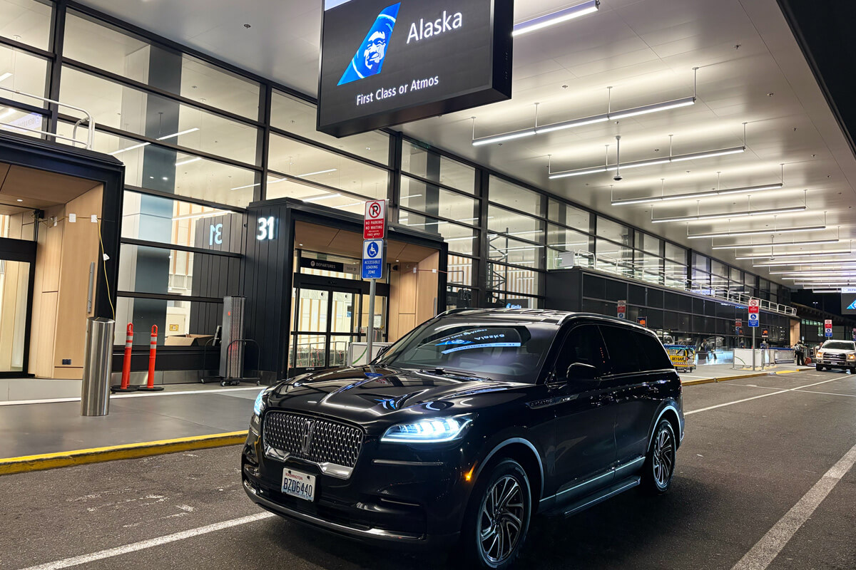 Black luxury SUV at SeaTac Airport curbside for private airport transportation