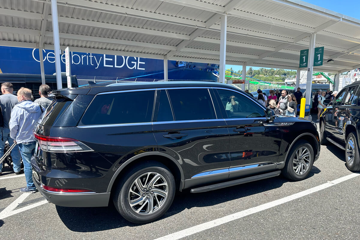 Black SUV pickup near a Seattle cruise ship for pier transportation