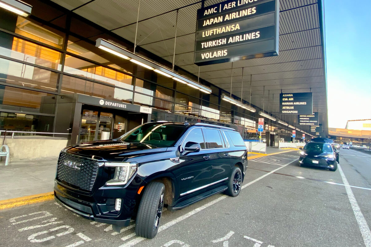 Black GMC Yukon at the SEA Airport departures curb outside the terminal
