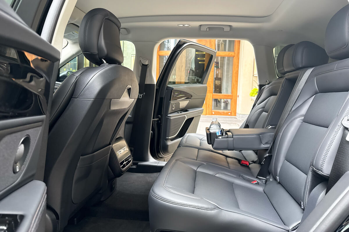 Rear passenger seating inside a black luxury SUV used for private transportation