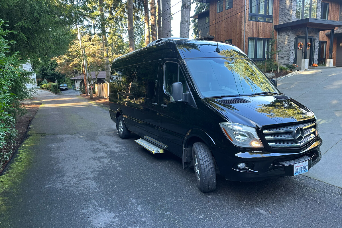 Black Mercedes Sprinter van at a residential pickup location for private event transportation