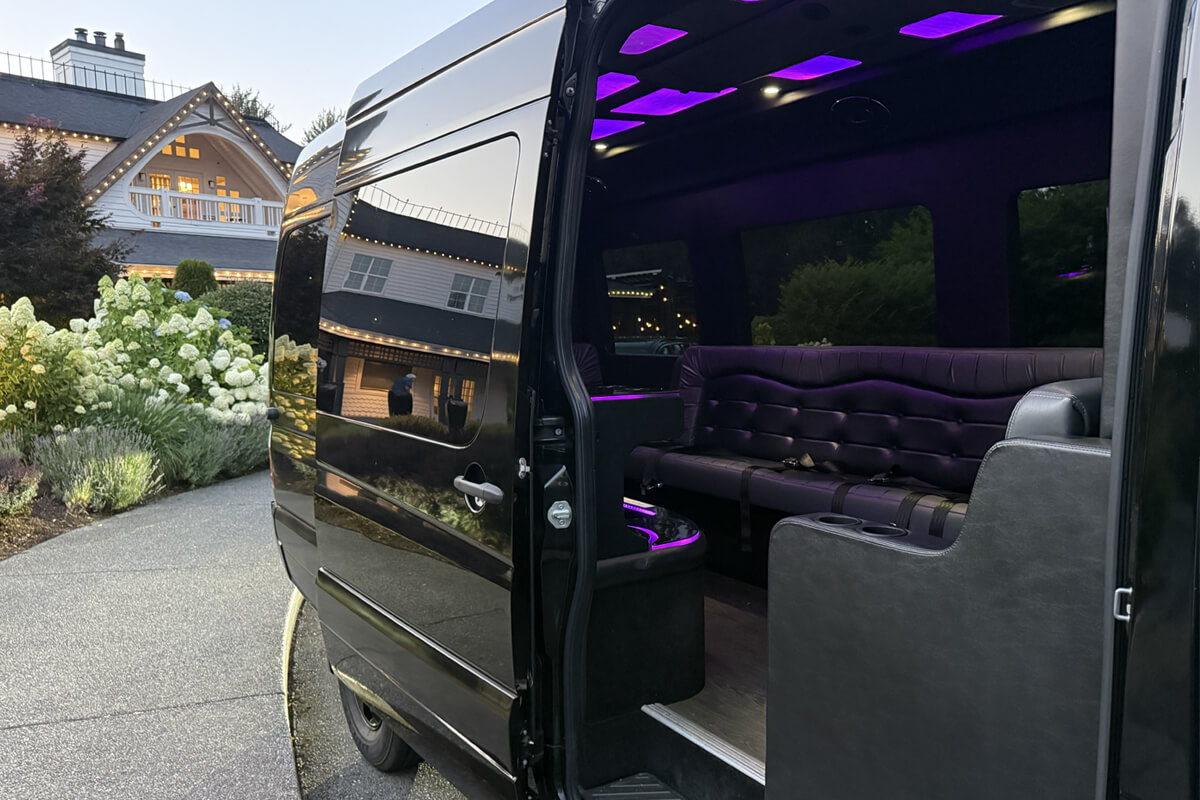 Black party bus with spacious seating and purple interior lighting for group event transportation